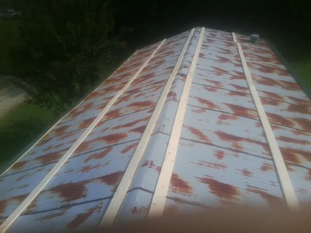 Rusted metal roof panels with new wood purlins before replacement — Storm Damage Roof Repair in Bly by Roofing Brothers