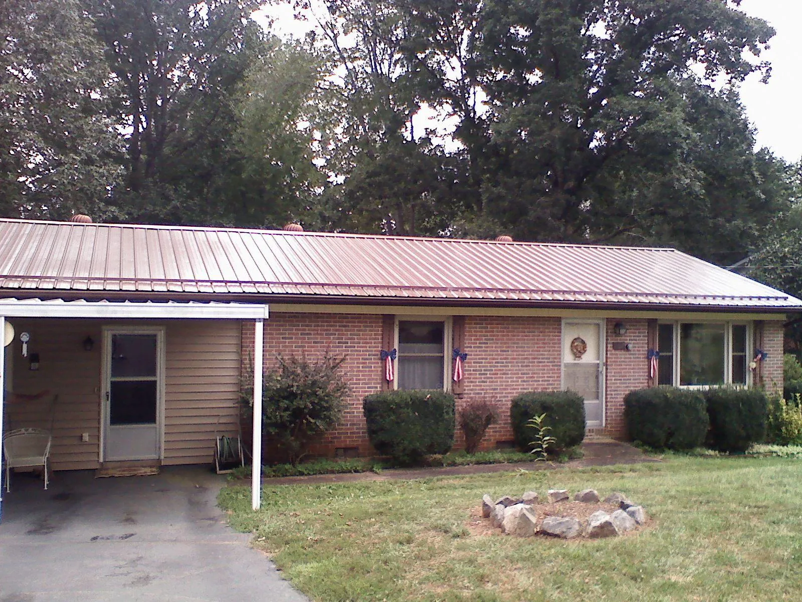 Bronze metal roof and carport on a brick ranch home — Roof Repair work by our crew in Bly